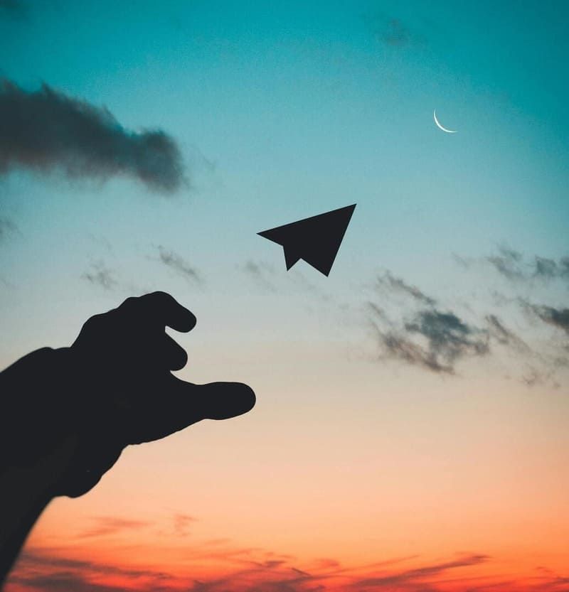 Un homme envoi un avion en papier vers le ciel